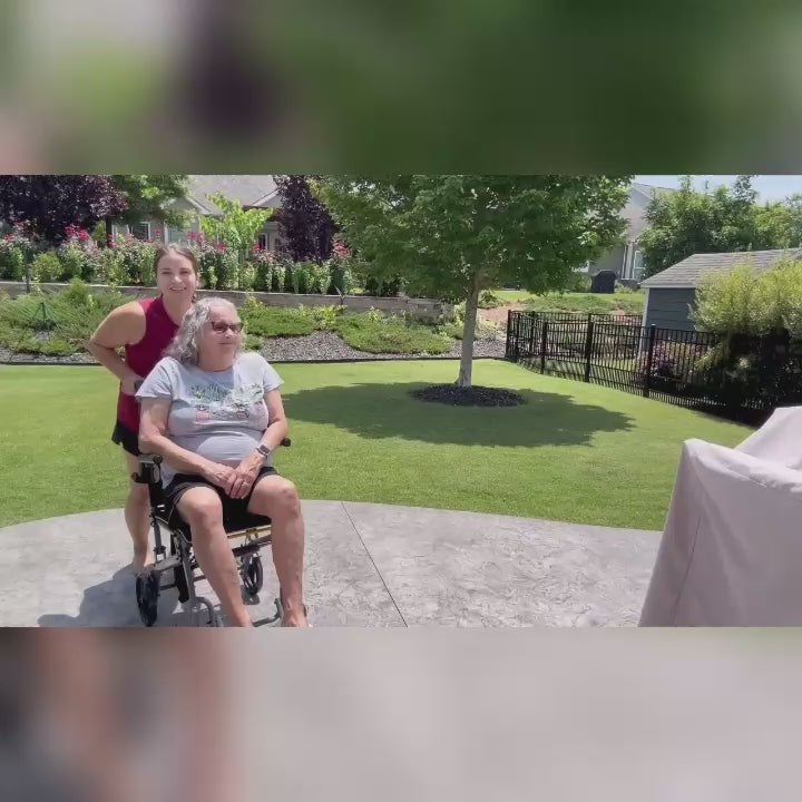 A daughter pushes her elderly mother in a WHLICKS transport wheelchair outdoors, showing smooth mobility and user satisfaction for seniors.