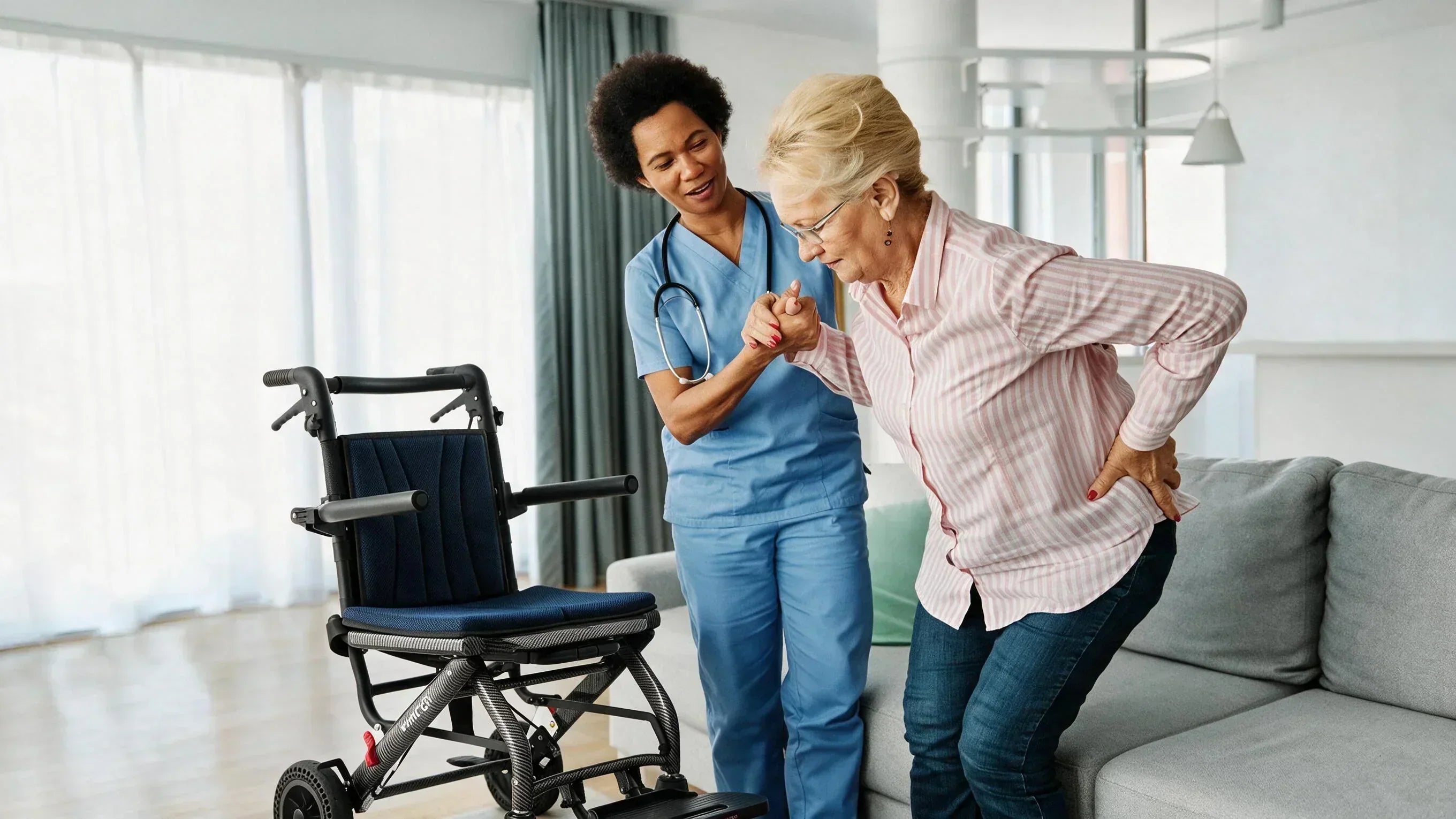 Caregiver helping senior stand from a sofa at home