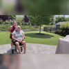 A daughter pushes her elderly mother in a WHLICKS transport wheelchair outdoors, showing smooth mobility and user satisfaction for seniors.